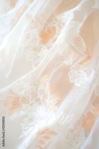 Close-up of delicate peach and white embroidered fabric with soft folds.