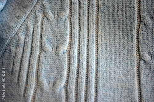 Knitted products, light blue women's woolen sweater with interesting patterns, knitting in the form of a braid, gathered elastic, different weaves and stitching.