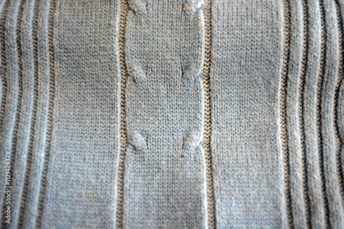 Knitted products, light blue women's woolen sweater with interesting patterns, knitting in the form of a braid, gathered elastic, different weaves and stitching.