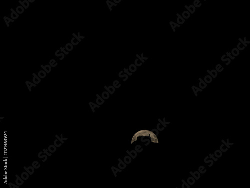 Silhouette of a church on top of a hill with the moon behind in the background. 