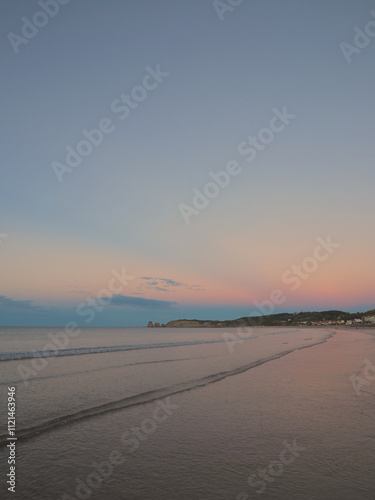 Sunset on the beach with the cliff and clouds in the background. 