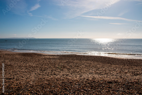 A view of the where the sand and peddles meet the cold icy ocean water and the beach photo