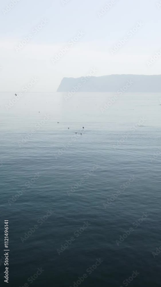 Vertical aerial view on sea water surface, camera flies over clear sea water. Sun glare. Abstract nautical summer ocean nature. Holiday, vacation and travel concept. Nobody. Weather and climate change Vertical aerial view on sea water surface, camera flies over clear sea water. Sun glare. Abstract nautical summer ocean nature. Holiday, vacation and travel concept. Nobody. Weather and climate change