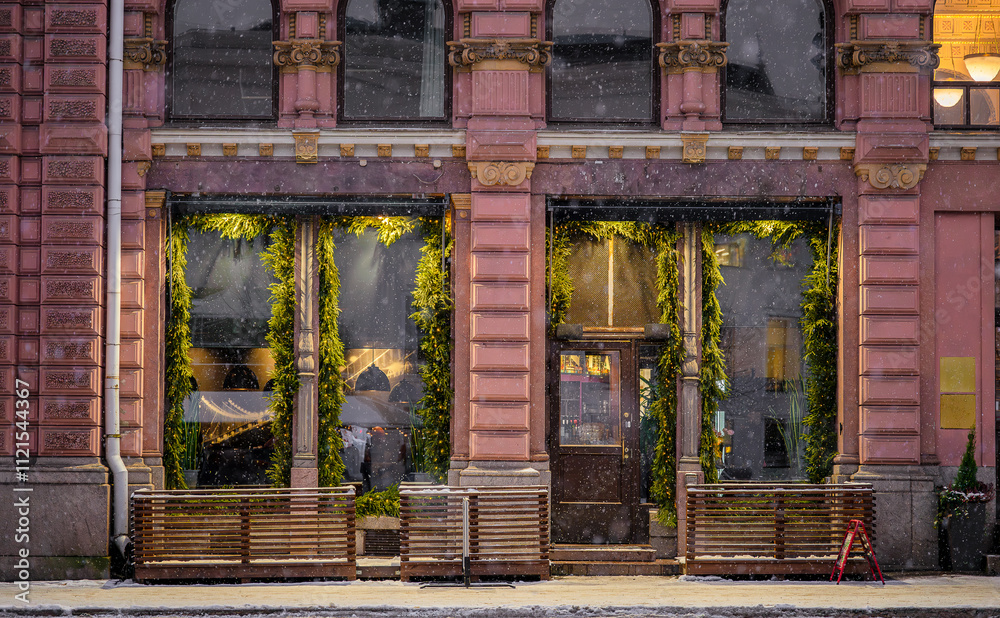 Festive storefront of a classical building with snow falling. Urban street holiday atmosphere Festive storefront of a classical building with snow falling. Urban street holiday atmosphere