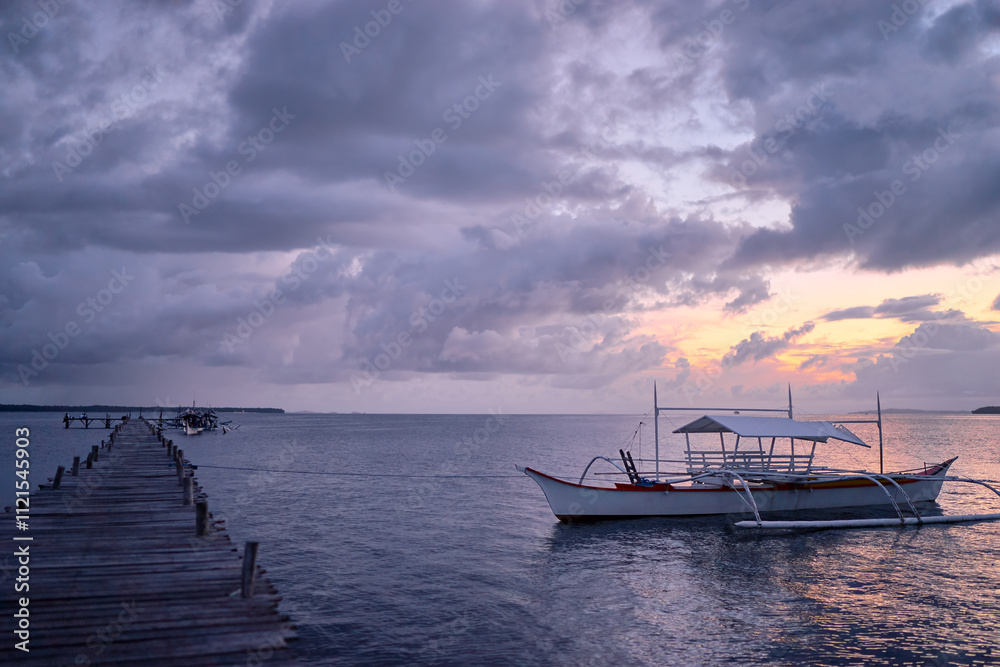 Obraz premium Beautiful colorful sunset on the seashore with fishing boats. Philippines, Siargao Island.