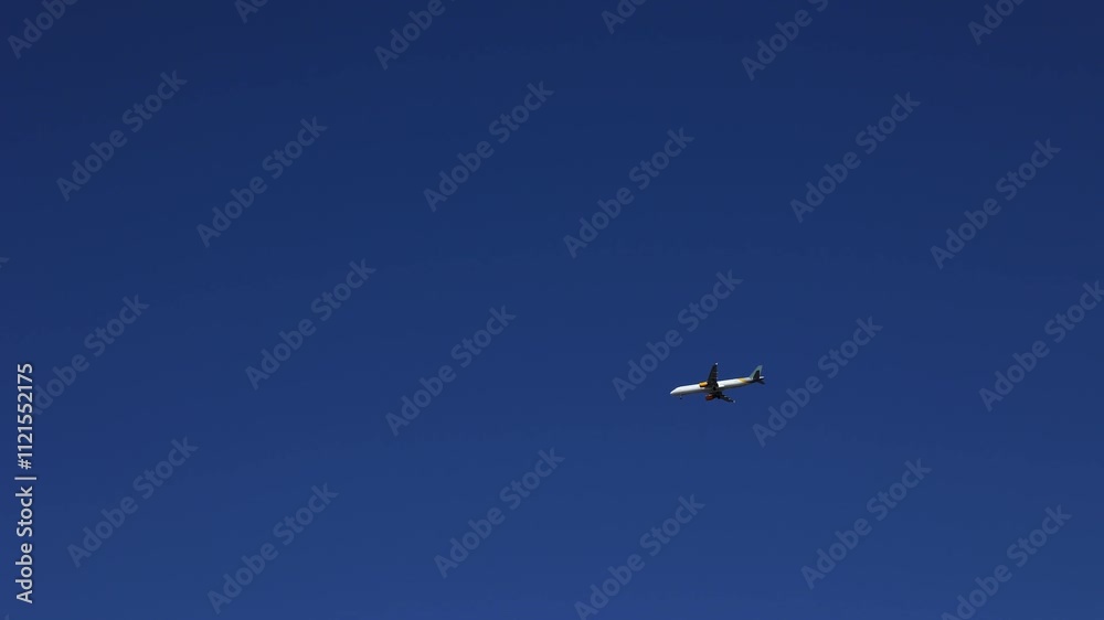 Airplane flies through the blue sky on a beautiful sunny day Airplane flies through the blue sky on a beautiful sunny day