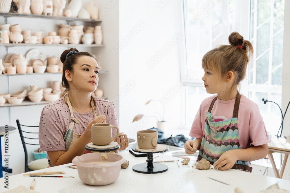 A mother and daughter enjoy pottery making in a bright studio space A mother and daughter enjoy pottery making in a bright studio space
