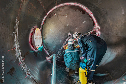 Inside male worker into the inspection shiny tank industrial construction oil and gas or storage tank oil chemical into area
