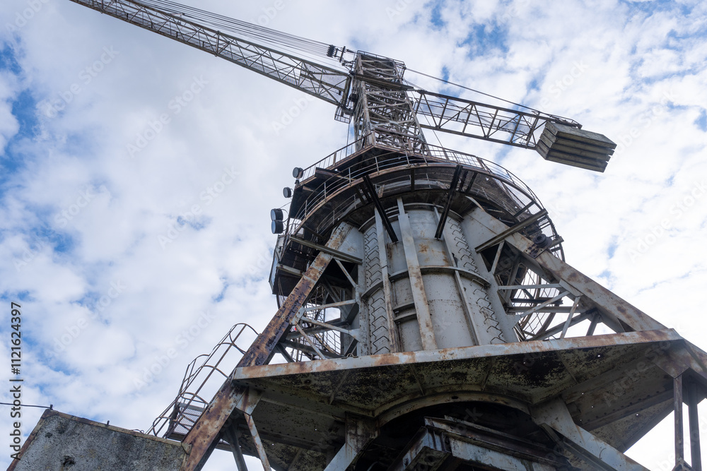 Industrial Crane against a Cloudy Sky in an Abandoned Sulfur Extraction Site Industrial Crane against a Cloudy Sky in an Abandoned Sulfur Extraction Site