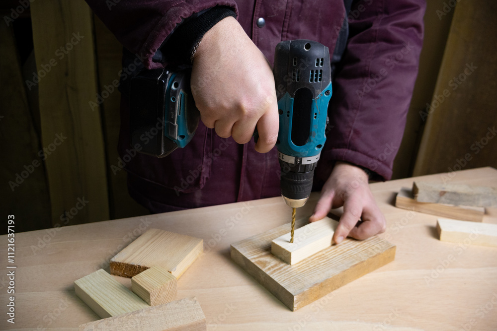 Drilling machine working on a piece of wood material Drilling machine working on a piece of wood material