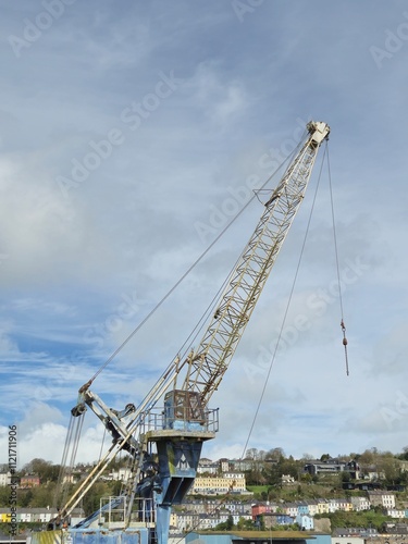 Construction Crane Near Water with Vehicles and Cloudy Sky