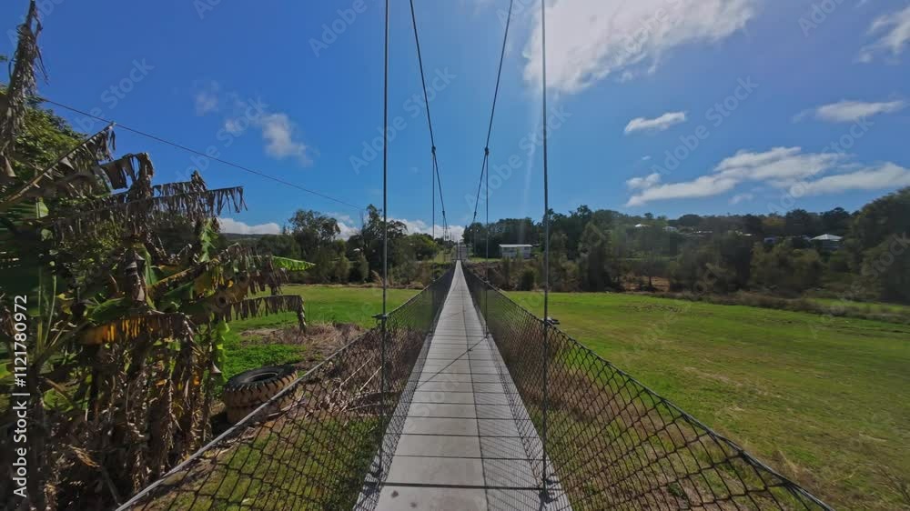 Mount Morgan Suspension Bridge spanning on a wide, green field with trees in the background Mount Morgan Suspension Bridge spanning on a wide, green field with trees in the background