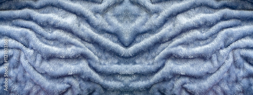 Texture of gray faux fur with wavy symmetrical folds. Abstract background for your design.