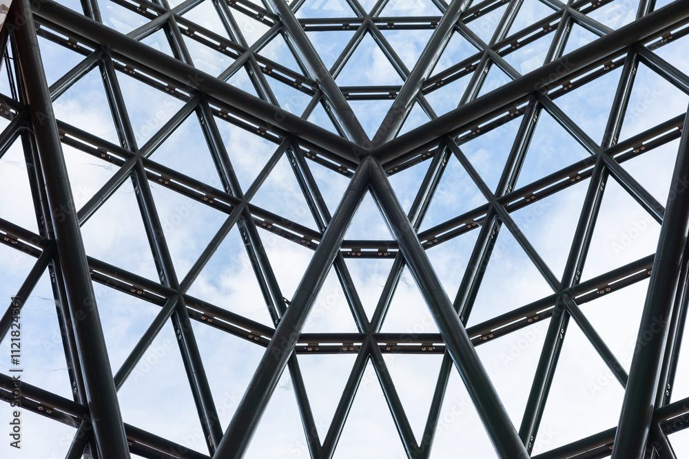 A large steel structure with the clear glass window with many triangles and a clear blue sky. A large steel structure with the clear glass window with many triangles and a clear blue sky.
