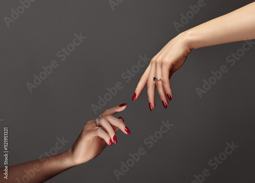 Elegant female hands with bright manicure. Square nails with red gel polish. Luxury fashion style of brilliants jewelry