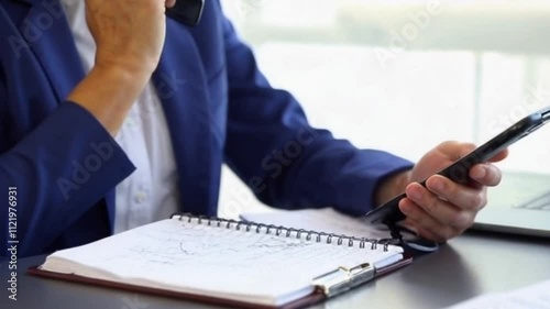 medical claims examiner speaking phone desk notepad scribbled notes or claims examiner communicating important information in busy environment or phone discussion medical claims office setting
