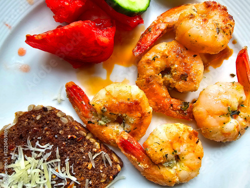 Grilled prawns with bread and vegetables on a white plate