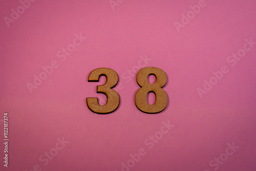 Number 38 in wood on a pink background photo