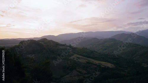 Mountain landscape view with soft rolling hills under a vibrant sunset sky
