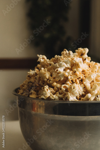 Vibrant and appetizing image of a bowl full of popcorn. The composition is perfect for illustrating concepts related to food, celebration, fun and joy.