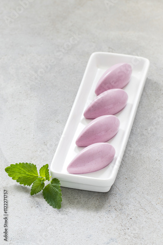 Modern Black Grape cream quenelles. On a plate. Close-up