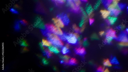 Beautiful bokeh and light reflections.Abstract sun burst, iridescent glare over black background. Wide angle horizontal wallpaper.
