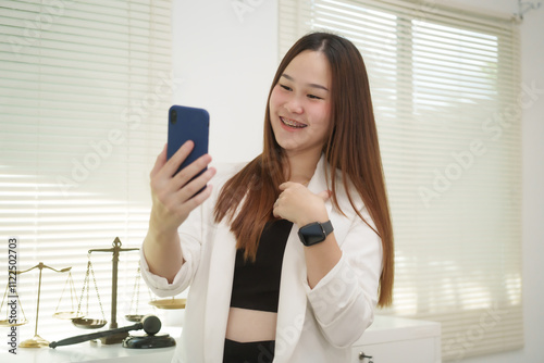 A cheerful businesswoman works at her office desk as a legal consultant, handling online civil cases, including debt disputes, unfair dismissals, foreclosures, land redemptions, with professionalism photo