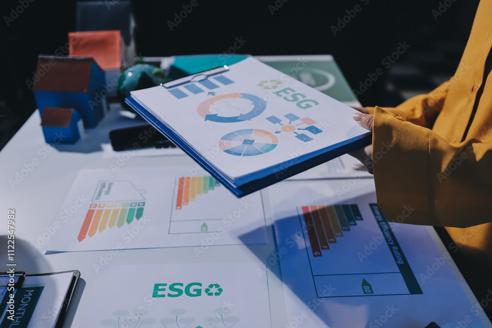 Fototapeta premium ESG environmental social governance display on laptop on eco-friendly company meeting with business people implementing environmental protection for clean and sustainable future ecology. Trailblazing