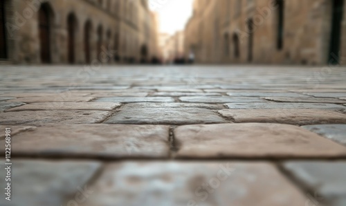 A close-up view of cobblestone street paving in an old historic city during the day, with soft lighting and empty road.