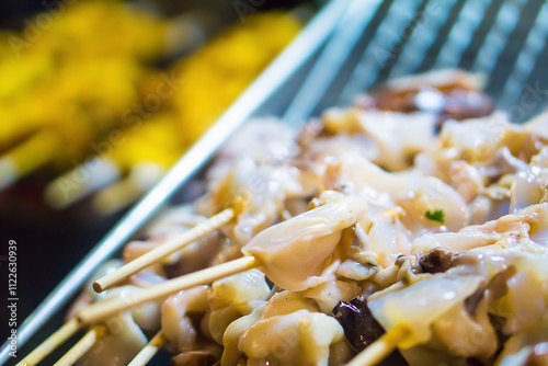 Fresh squids with bamboo sticks for grilling at a street food in Thailand.