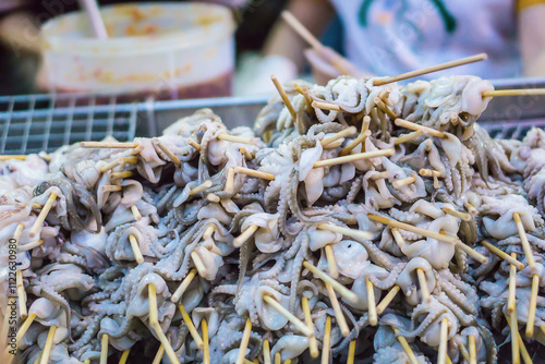 Fresh squids with bamboo sticks for grilling at a street food in Thailand.