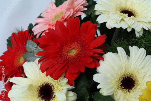 Many kinds of flowers placed in a brightly colored vase
