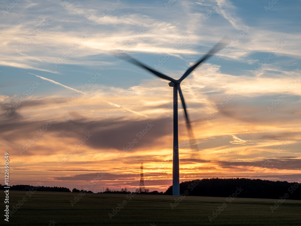 Obraz premium Spinning wind turbines at sunrise