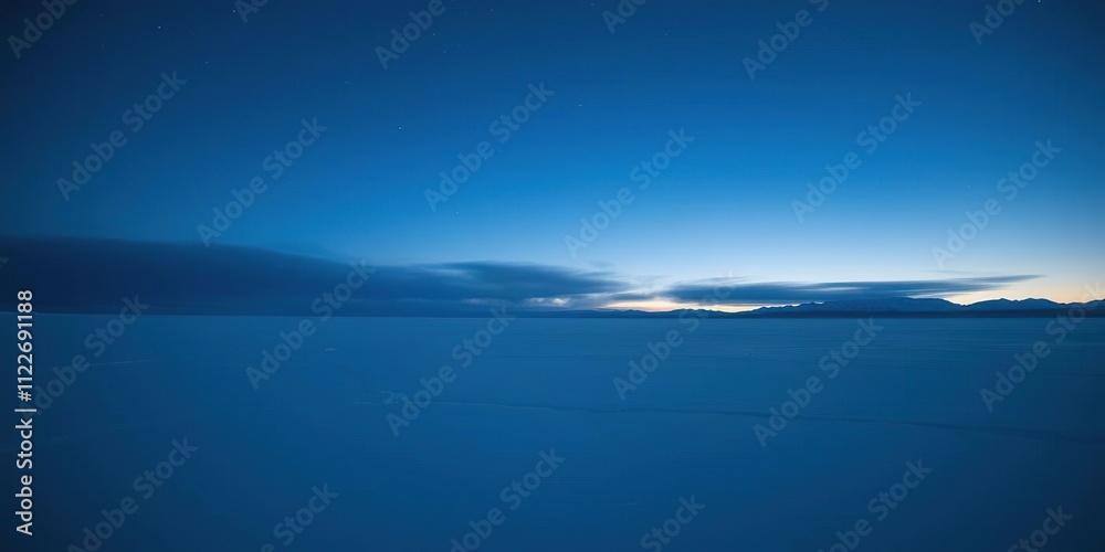 Obraz premium The stunning arctic landscape at night with a vast and calm frozen lake under an endless blue sky, frosty atmosphere, arctic landscape, serene landscape