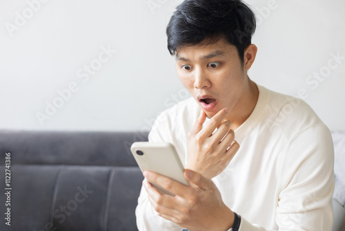 close up adult asian man using smartphone with emotional surprise and excited feeling after reading news on application or website for lifestyle people concept photo