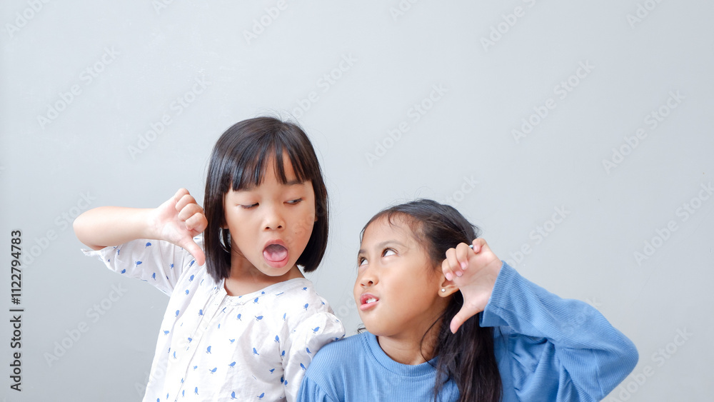 Young girl teasing and mocking a friend - sticking her tongue out, isolated on gray background. Young girl teasing and mocking a friend - sticking her tongue out, isolated on gray background.
