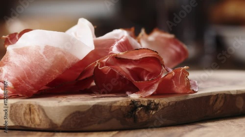 Slow motion prosciutto falling on wood board