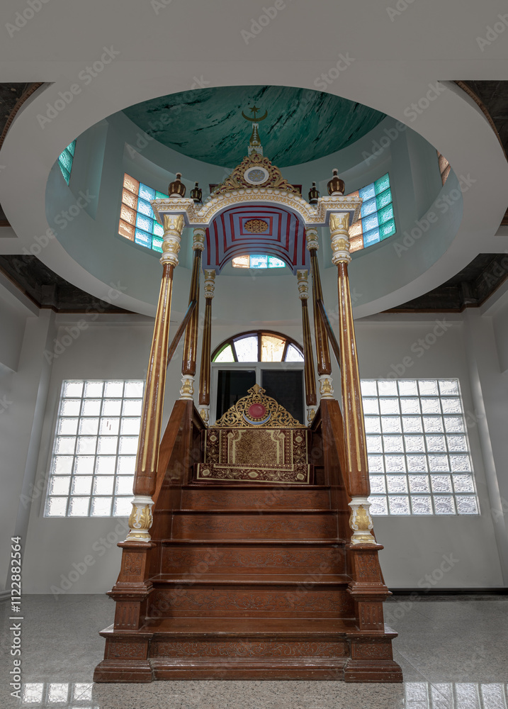 Ornately decorated minbar pulpit from where prayers are led standing on a platform at Safirusslam Mosque. Islamic Affairs, use it as your Wallpaper, Poster and Space for text. Selective focus.