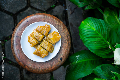 Top view of a signature dish of Pontianak, Indonesia called srikaya fried banana on a wooden stool