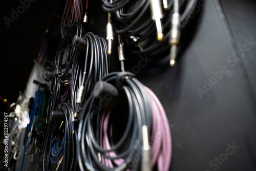 Lots of different audio cables with connectors. Wires on a rack in an art studio.