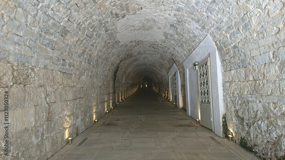 Obraz premium Athens, Greece - 29.3.2018: A semi-circular marble tunnel under marble steps leading to the Museum of Panathenaic Stadium in the Atrium Hall without tourists before the pandemic