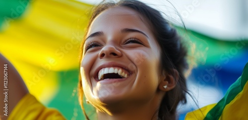 Happy young girl football fan celebrating her team victory, laughing and smiling. Brazil flag background.