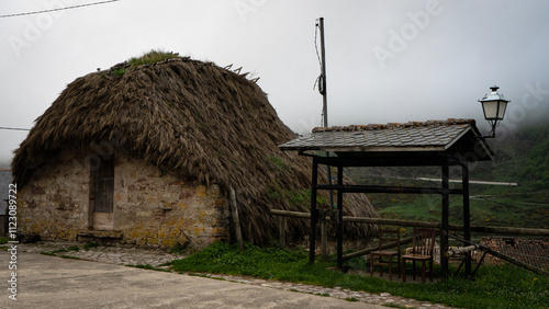 Traditional thatched roof hórreo in asturias, spain, on a foggy day