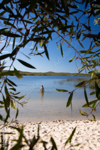 Looking through foliage to a lone female enjoying the solitude of Blue Lagoon