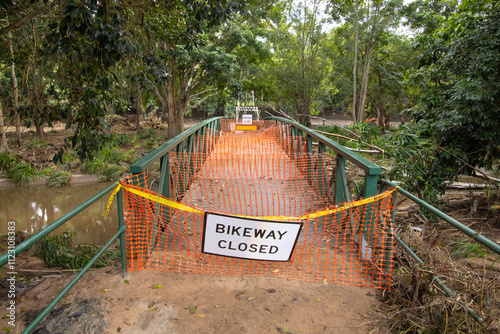 A safety barrier blocks a bridge crossing along a suburban bikeway after a flood event photo