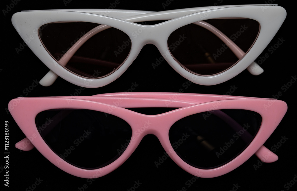 white and pink cat eye sunglasses on black background