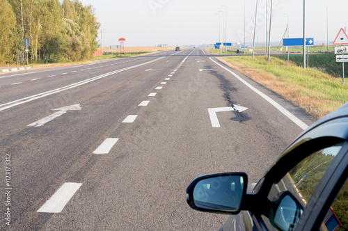 The car is parked in the right turn lane of the motorway
