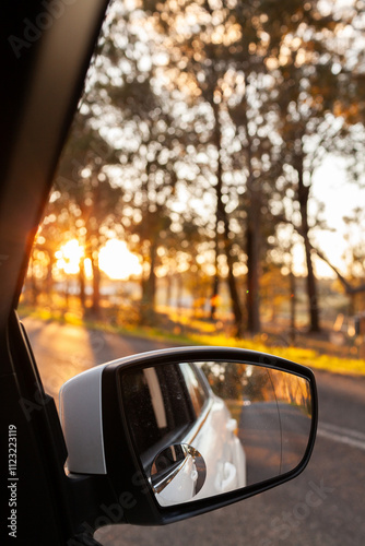 car rear view side mirror at sunset on the road photo