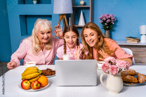 Family hving brakfast at home and using computer laptop photo