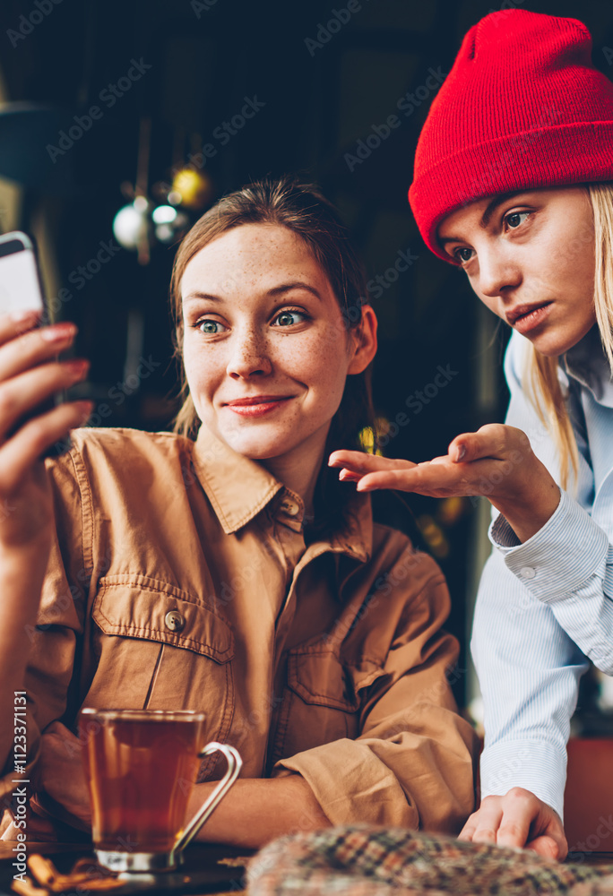 Φωτογραφία Wondered hipster bloggers discussing video on website wich watching online on smartphone device connected to 4G internet sitting in coffee shop